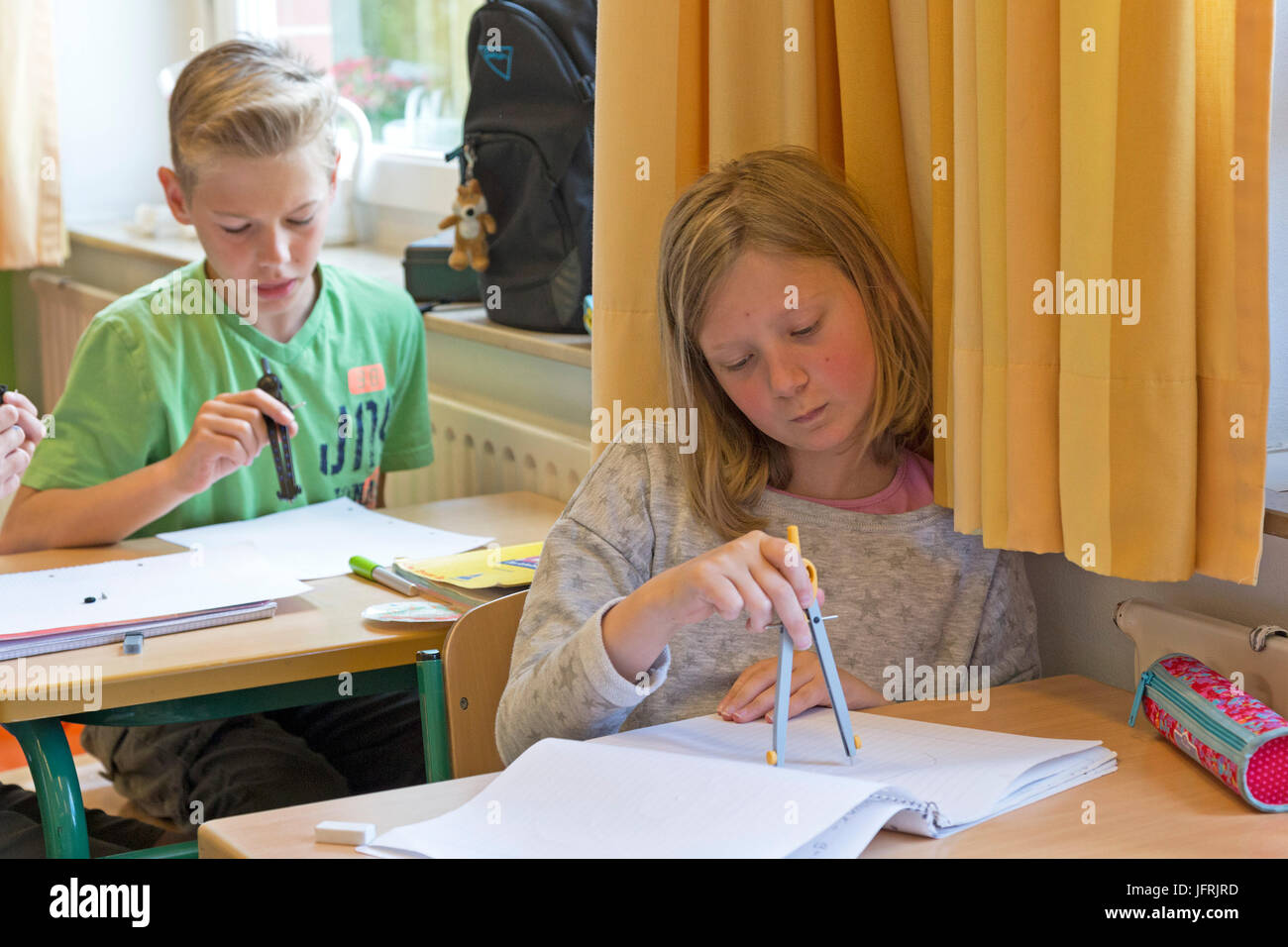Kinder im Grundschulalter arbeiten mit ihren Kompasse Stockfoto