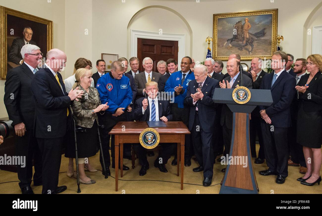 US-Präsident Donald Trump umgeben von Mitgliedern des Kongresses, Astronauten und kommerzielle Raumfahrtunternehmen Zeichen eine Executive Order, Raum Nationalrat im Roosevelt Room des weißen Hauses in Washington, DC 30. Juni 2017 wieder herzustellen. Vizepräsident Mike Pence, wird auch anwesend, den Rat den Vorsitz. Auch abgebildet sind, ehemaliger NASA-Astronaut David Wolf, links, Astronaut Alvin Drew, zweiter von rechts, und ehemaliger NASA Astronaut Legende Buzz Aldrin, rechts. Stockfoto