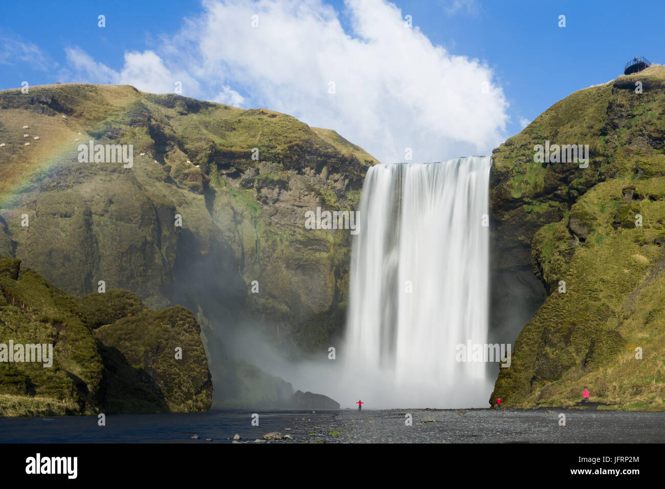 Skogafoss Wasserfall mit Touristen an der Basis der fällt, Island Stockfoto