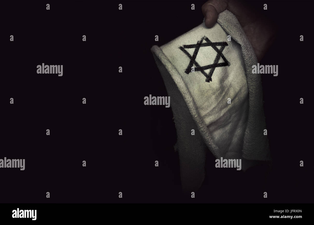 Nahaufnahme der jüdischen Abzeichen Stern von David in der Hand. Das Konzept der Erinnerung an den Völkermord an den Juden durch die Nazis während des zweiten Weltkriegs. Stockfoto