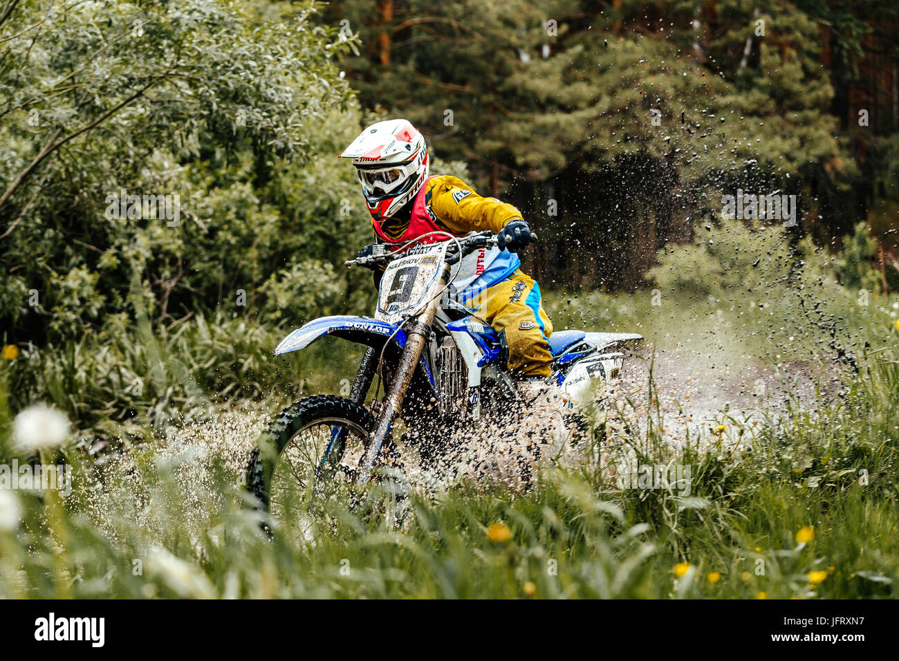 Motorrad überquert Pfützen von Wasser und Schlamm im Wald während Ural Cup in Enduro Stockfoto