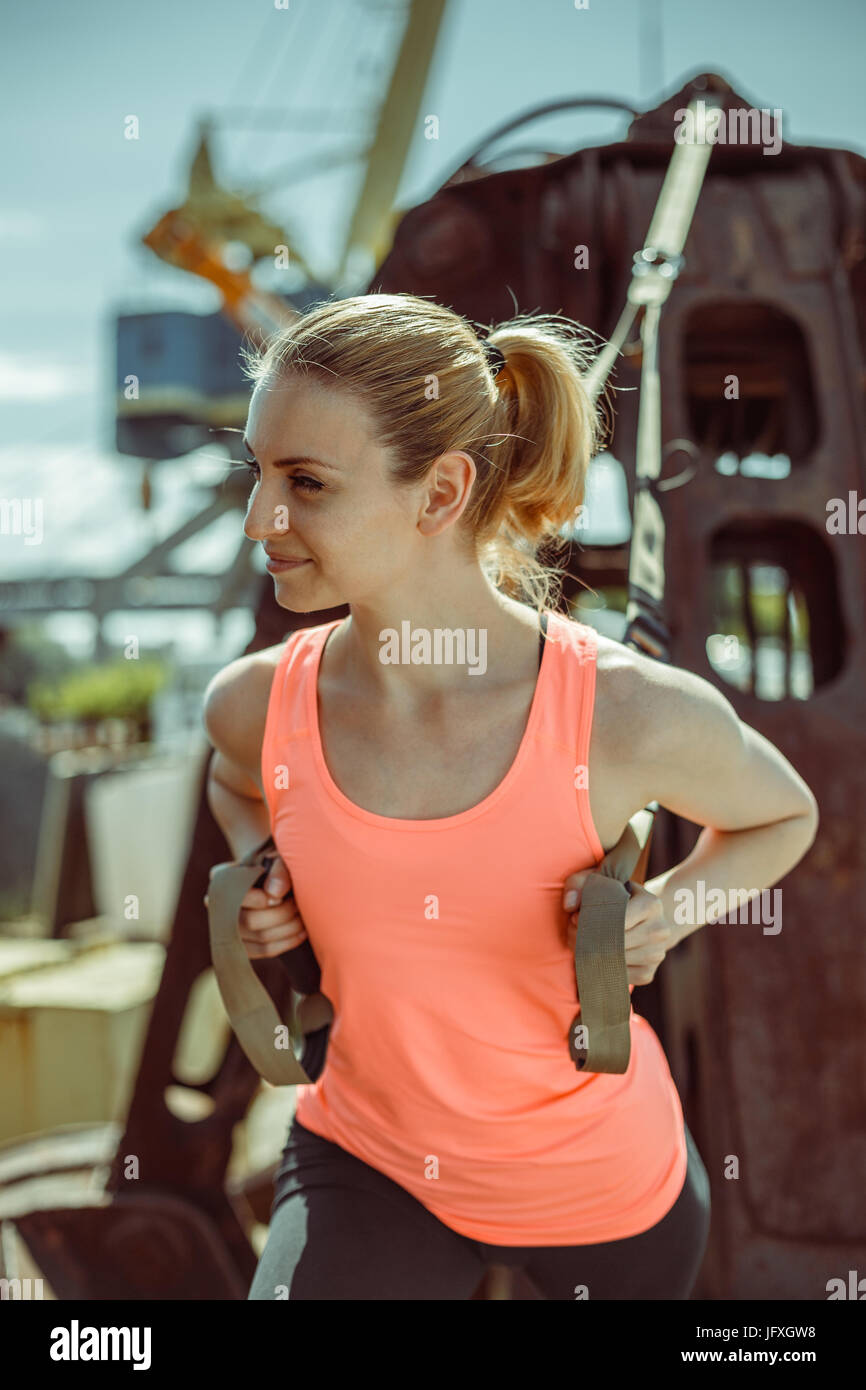 Close-up Portrait eines Sportlers in Uniform während des Trainings mit TRX Training im Freien. Stockfoto