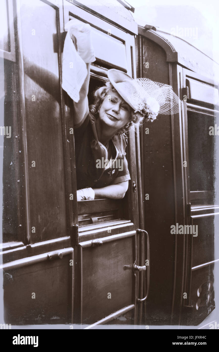 Reife Dame in Vintage Kostümen winken aus dem Fenster des Zuges Stockfoto