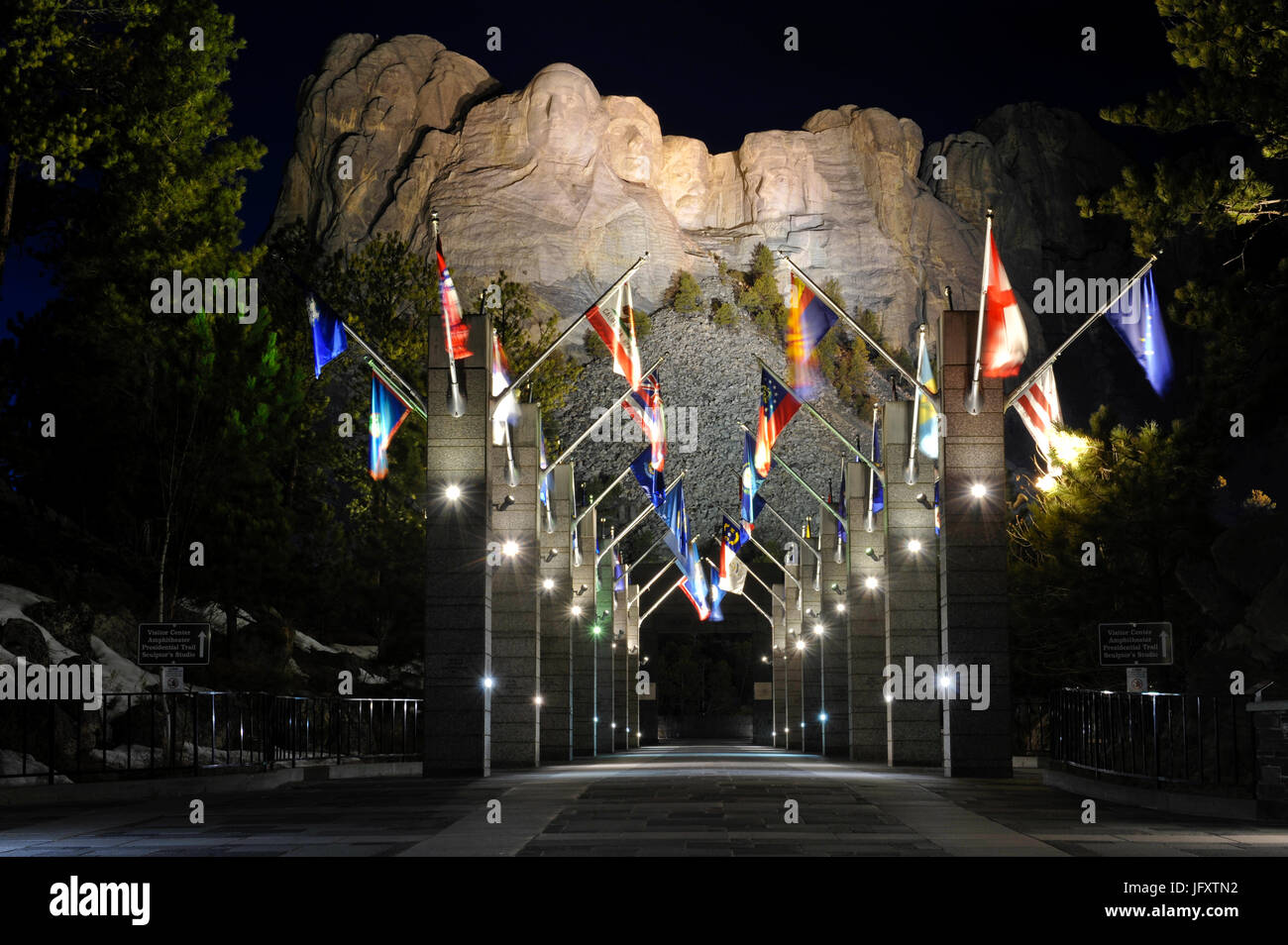 Internationale Fahnen Linie Grand View Eingang zum Mount Rushmore National Monument, wo vier ehemalige US-Präsidenten in der Nacht 24. März 2010 in Keystone, South Dakota in eine beleuchtete Granit-Felswand gehauen sind.     (Foto von Lance Cheung über Planetpix) Stockfoto