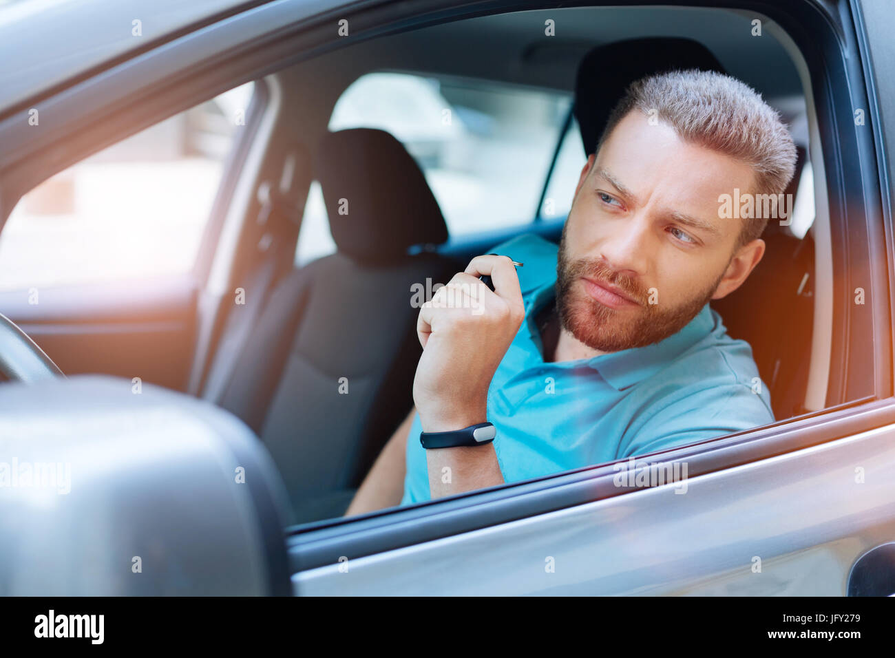 Gut aussehender Mann, die Überprüfung der Straße vor dem Start des Autos Stockfoto