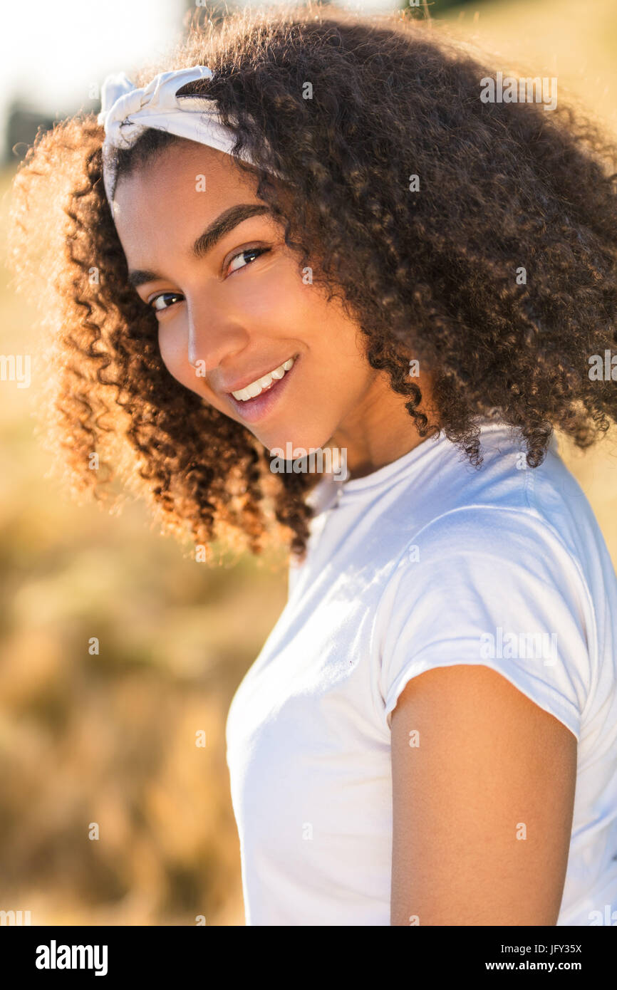 Outdoor Portrait der schönen glücklich gemischt Rennen afroamerikanische Mädchen Teenager Mädchen Lächeln mit perfekten Zähnen Stockfoto