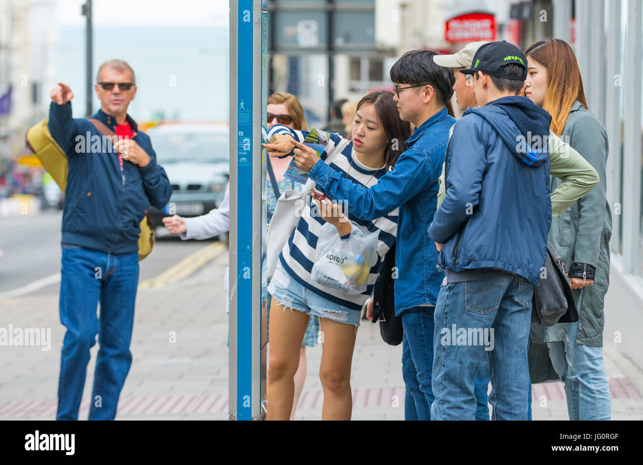 Japanische Touristen betrachten eine Straßenkarte in einer Stadt, um Richtungen zu finden. Stockfoto