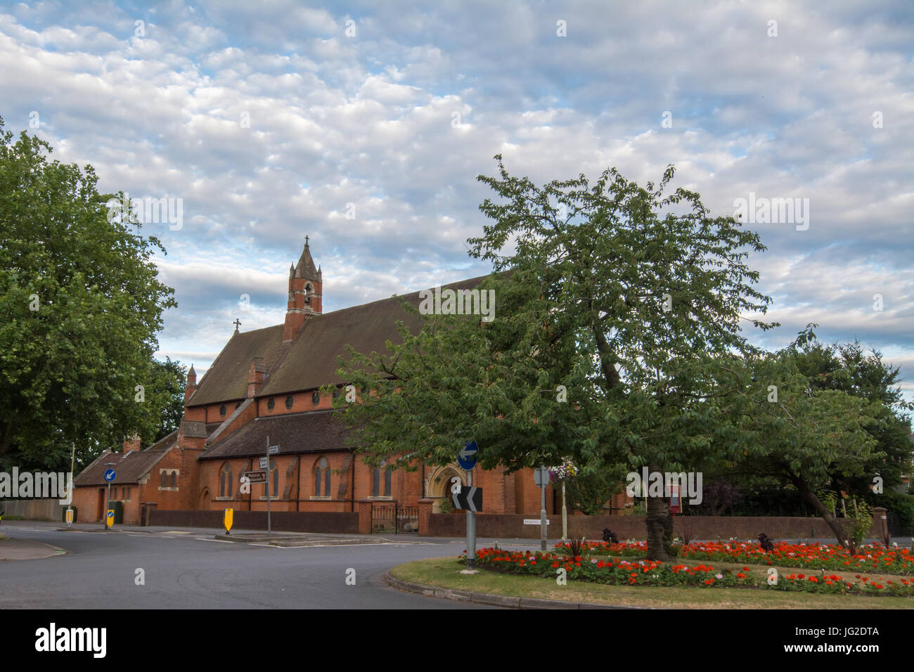 St Mark's Kirche in Farnborough, Hampshire, UK, im Sommer mit Blumen vorne Stockfoto