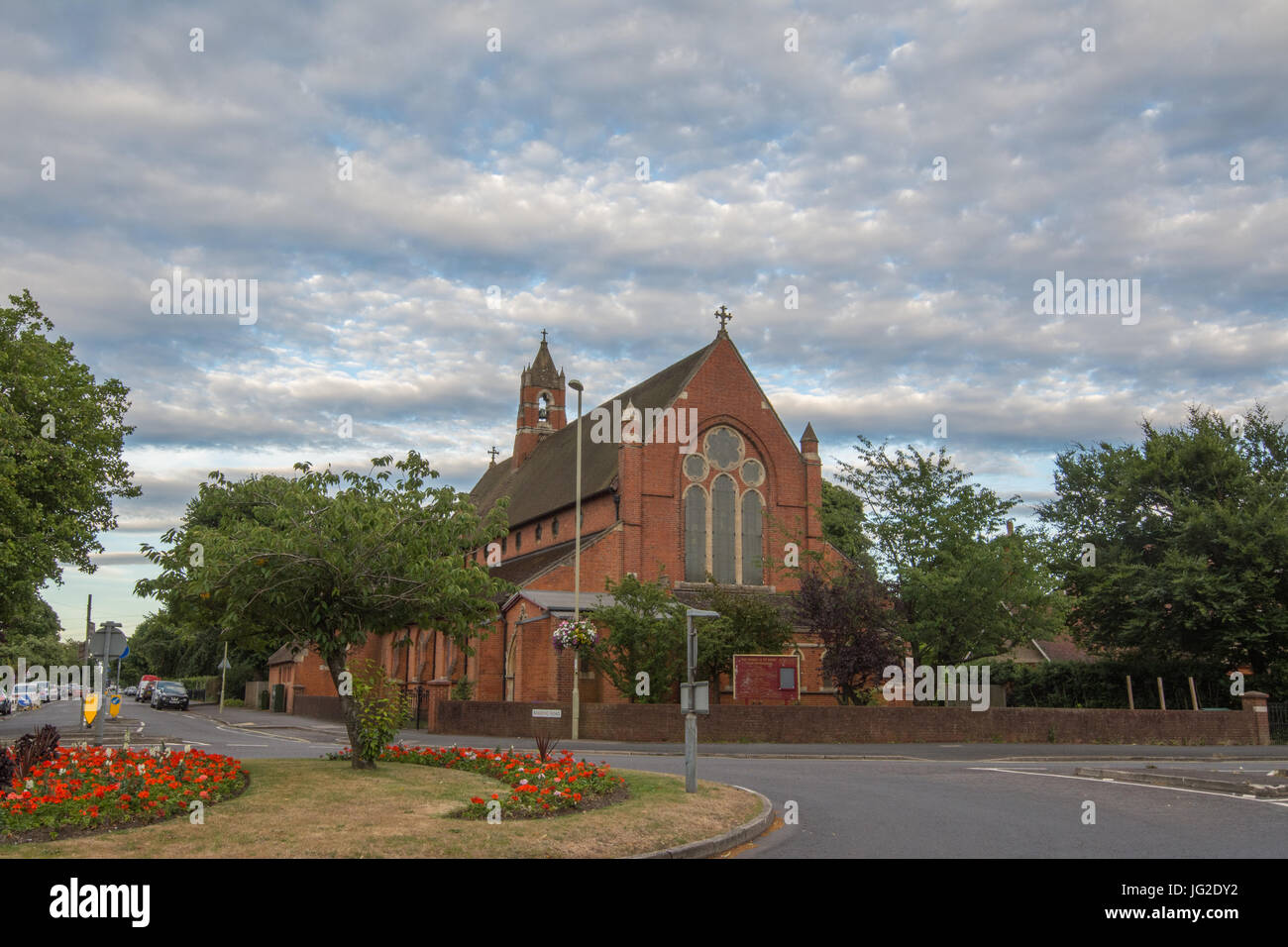 St Mark's Kirche in Farnborough, Hampshire, UK, im Sommer mit Blumen vorne Stockfoto