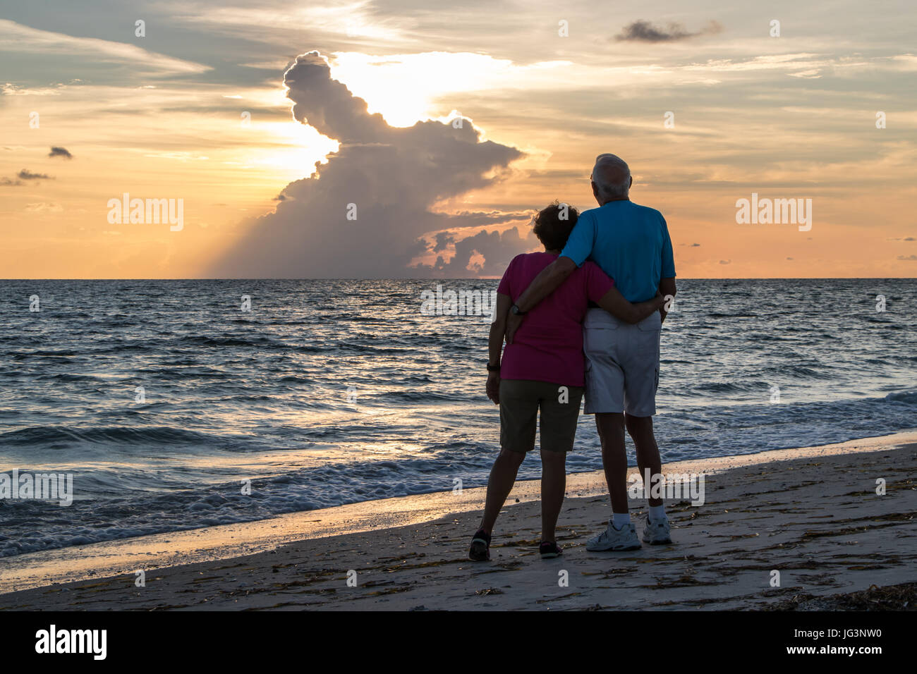 Ehepaar im Ruhestand umarmen am Strand Stockfoto
