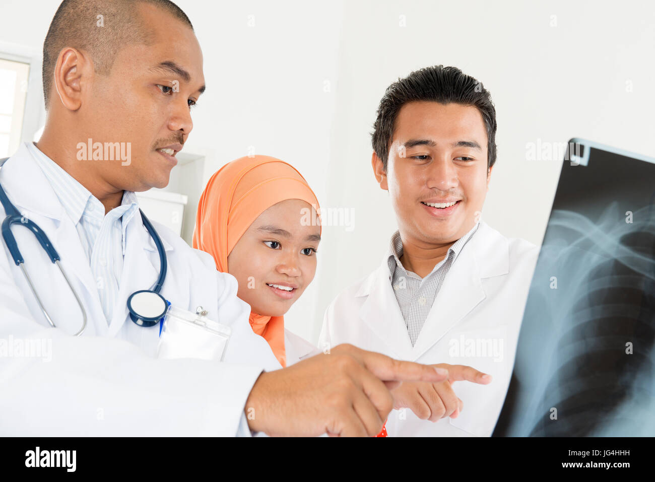 Ärzte untersuchen Radiographie im Amt. Südostasiatische muslimischen Menschen. Stockfoto