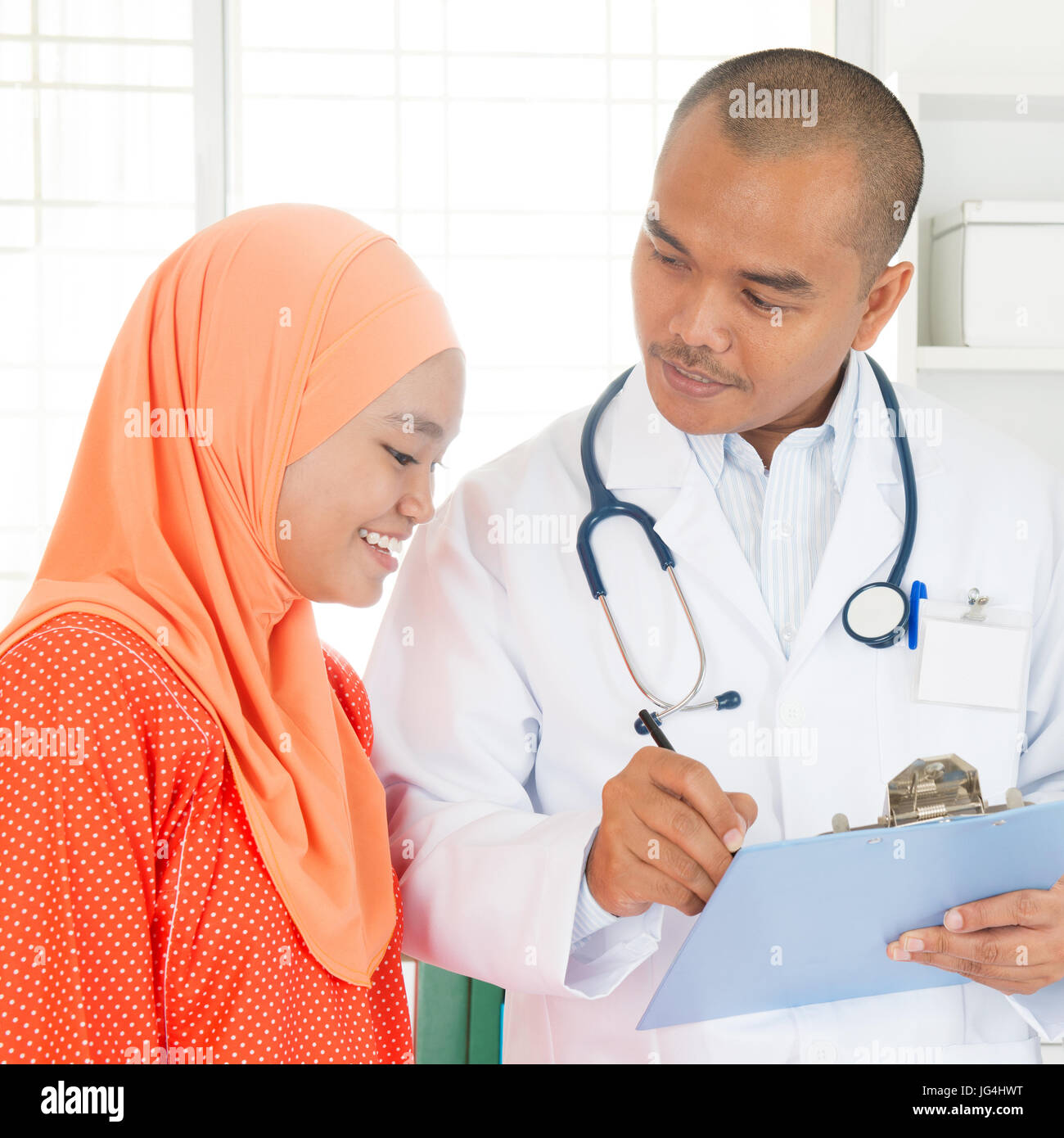 Arzt diskutieren Behandlungsmöglichkeiten mit Patienten. Südostasiatische muslimischen Menschen. Stockfoto