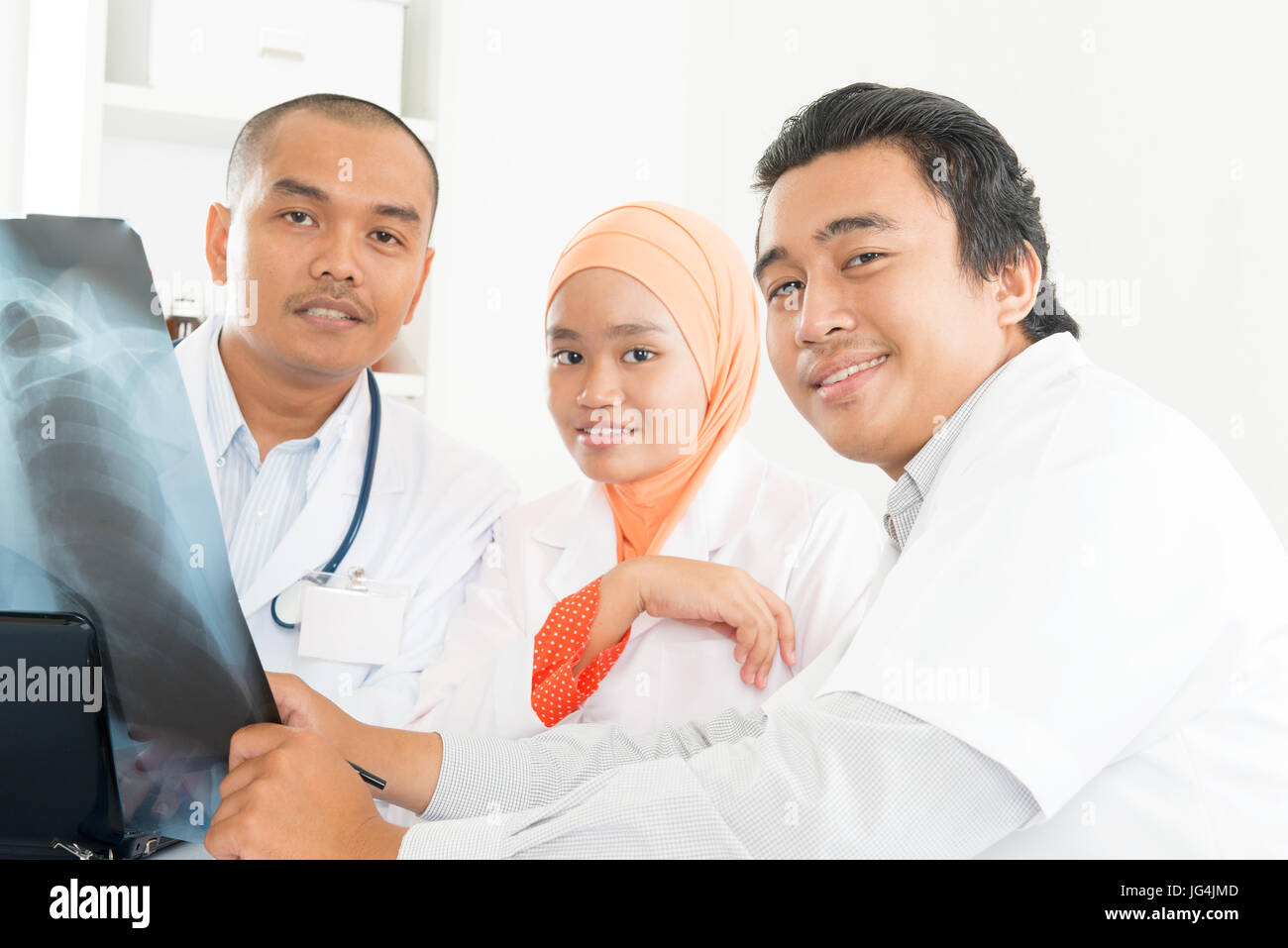 Ärzteteam untersucht Radiographie im Amt. Südostasiatische muslimische Ärzte und Krankenschwestern. Stockfoto