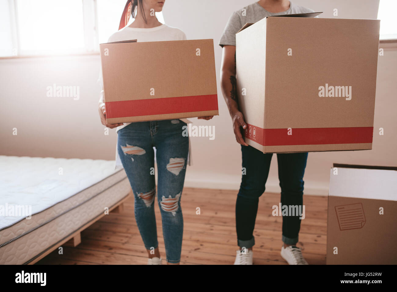 Junges Paar mit großen Kartons an neuen Ort verschieben. Schuss von Mann und Frau tragen große Kisten und der Umzug in neues Haus zugeschnitten. Stockfoto