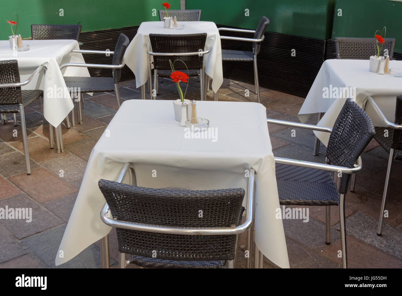 Tische in einem Restaurant leer mit weißen Tischtuch und einzelne romantische rote rose Speeddating Stockfoto