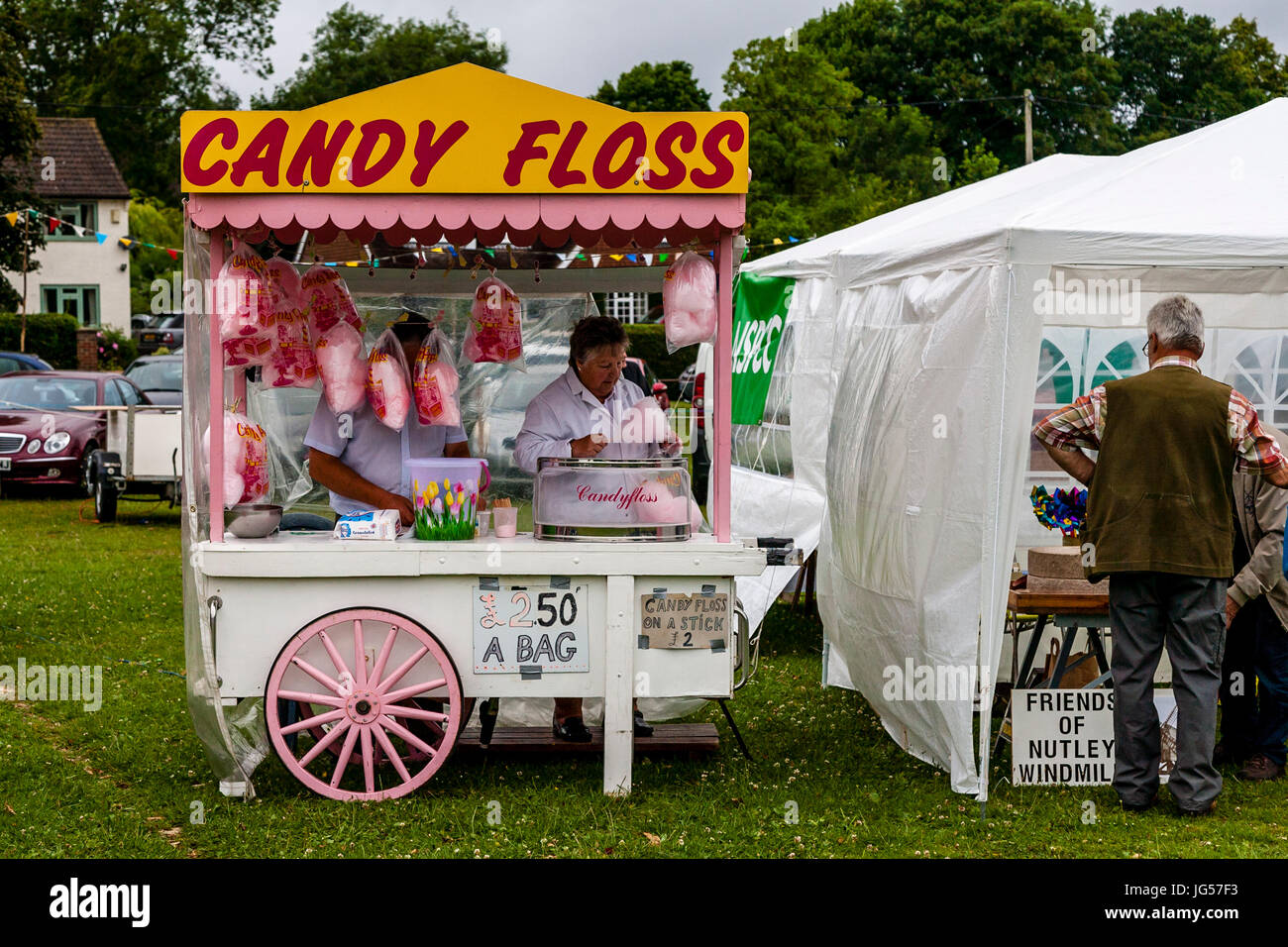Eine Frau verkauft Zuckerwatte aus einem bunten mobilen Stall, Nutley Dorffest, Nutley, Sussex, Großbritannien Stockfoto