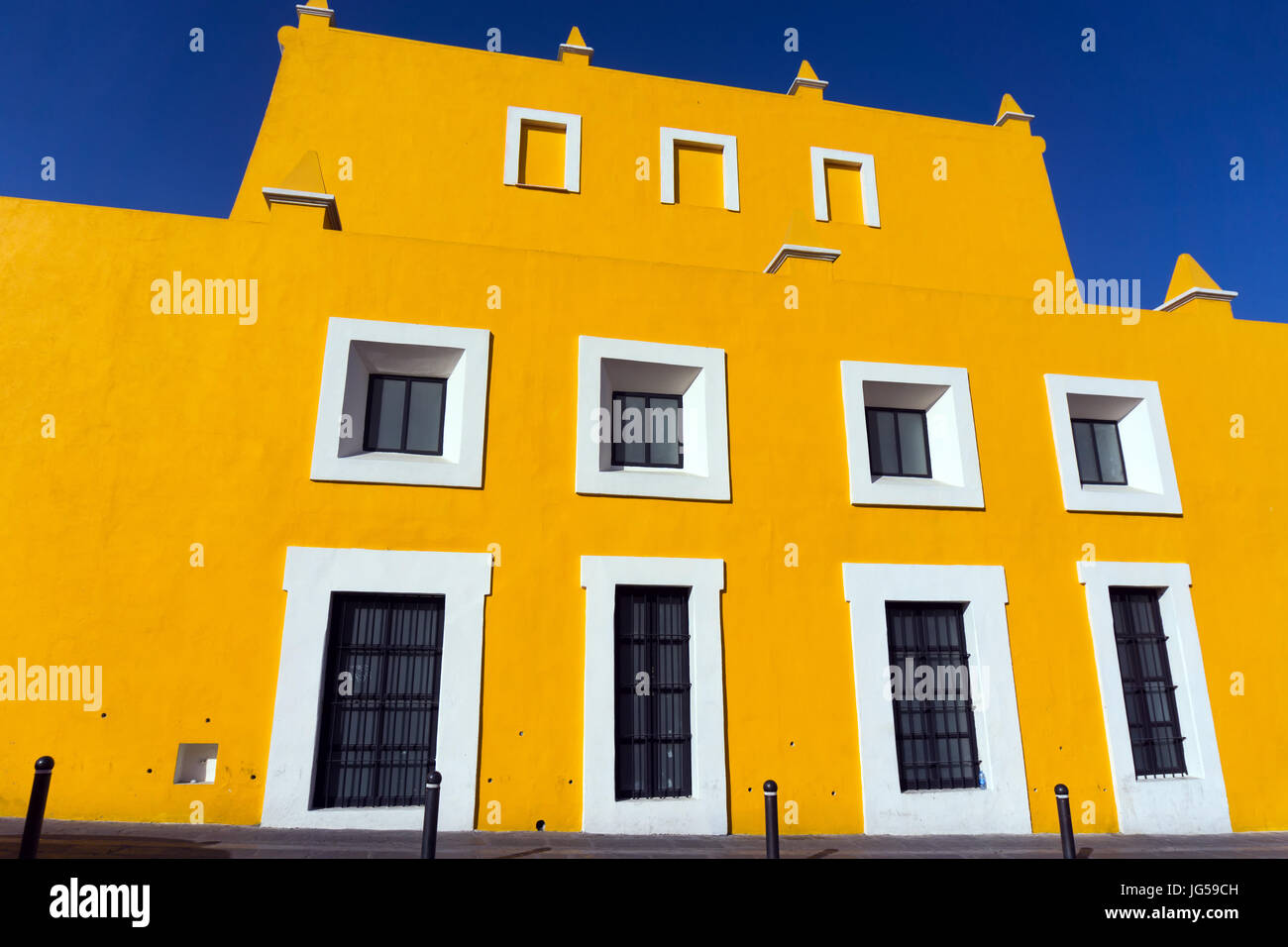 Gelbe Gebäude im Kolonialstil mit einem blauen Himmel in Puebla, Mexiko Stockfoto