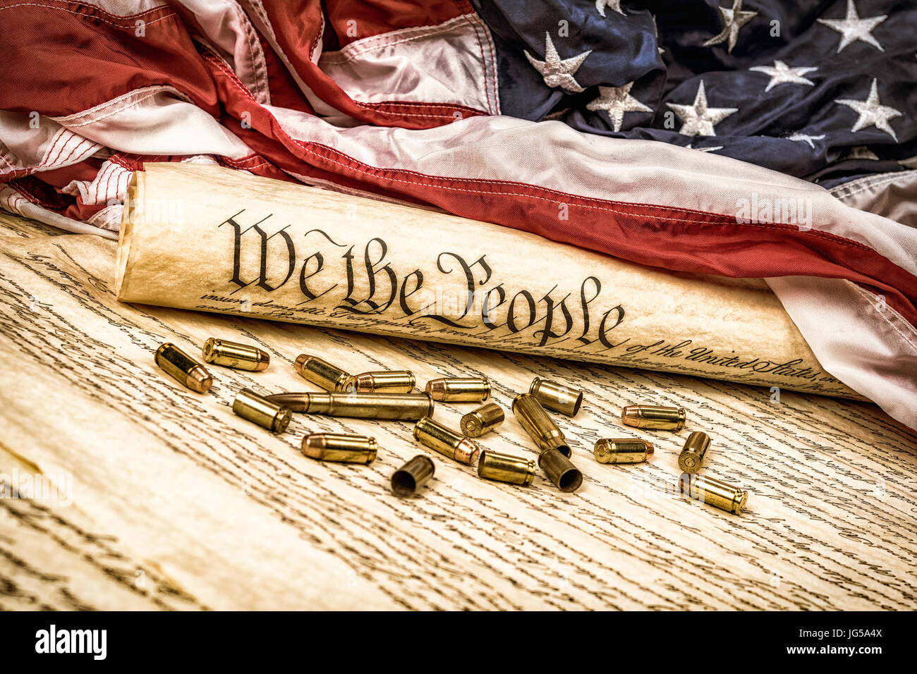 Verfassung der Vereinigten Staaten auf eine amerikanische Flagge aufgerollt mit Kugeln symbolisieren die zweite Änderung verstreut. Stockfoto