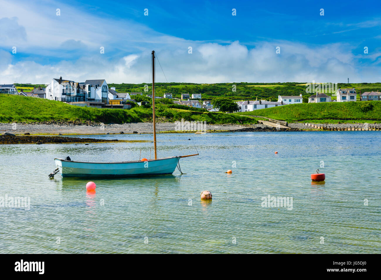 Kleines Segelboot mit einem Außenbordmotor in Portbalintrae Stockfoto