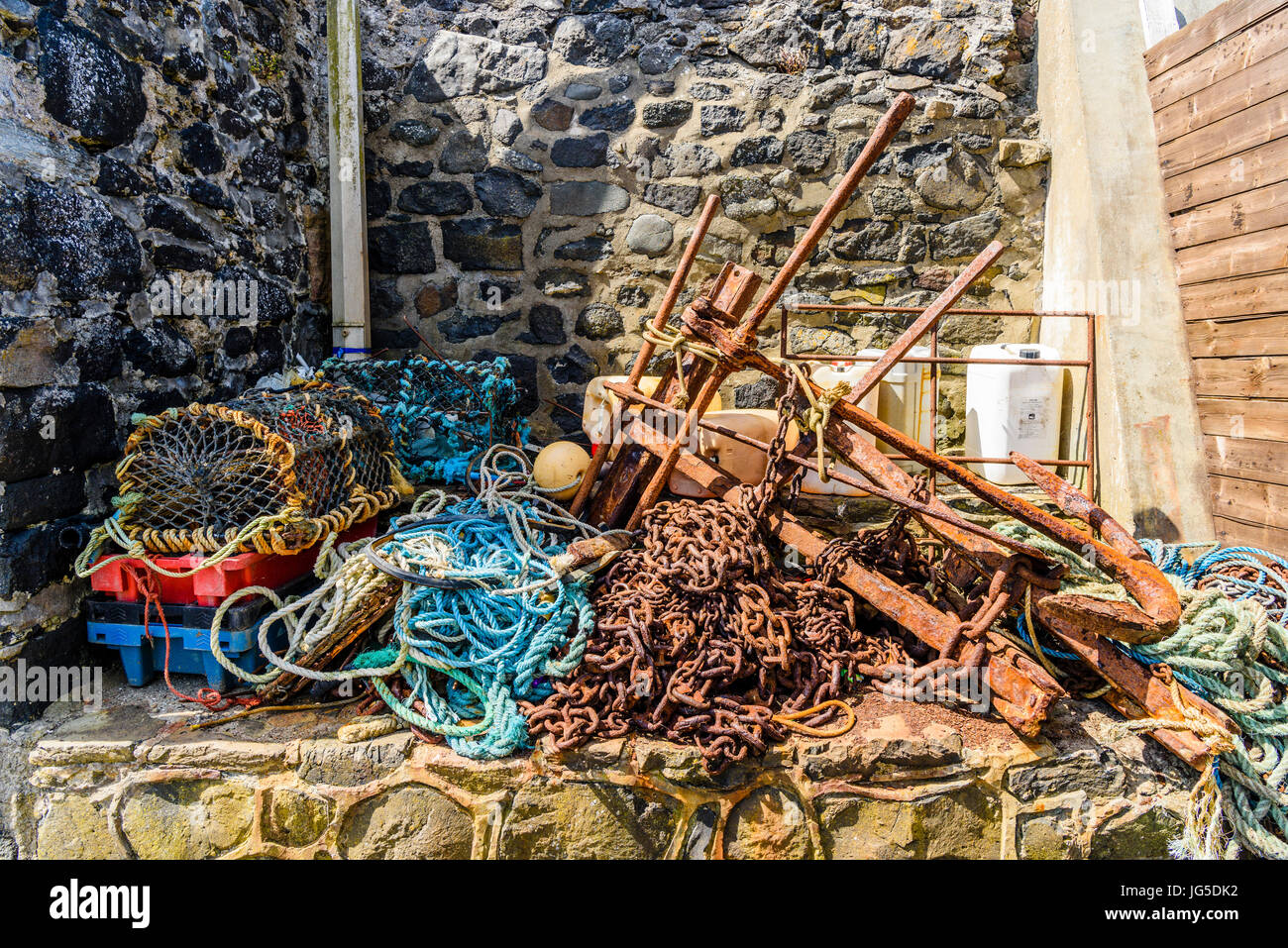 Ketten, Seile, Hummer Käfige und andere Ausrüstung für die Fischerei in einem alten Hafen. Stockfoto