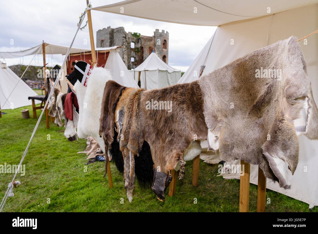 Tierhäuten hängen zum Trocknen auf ein mittelalterliches Lager neben einer Burgruine. Stockfoto