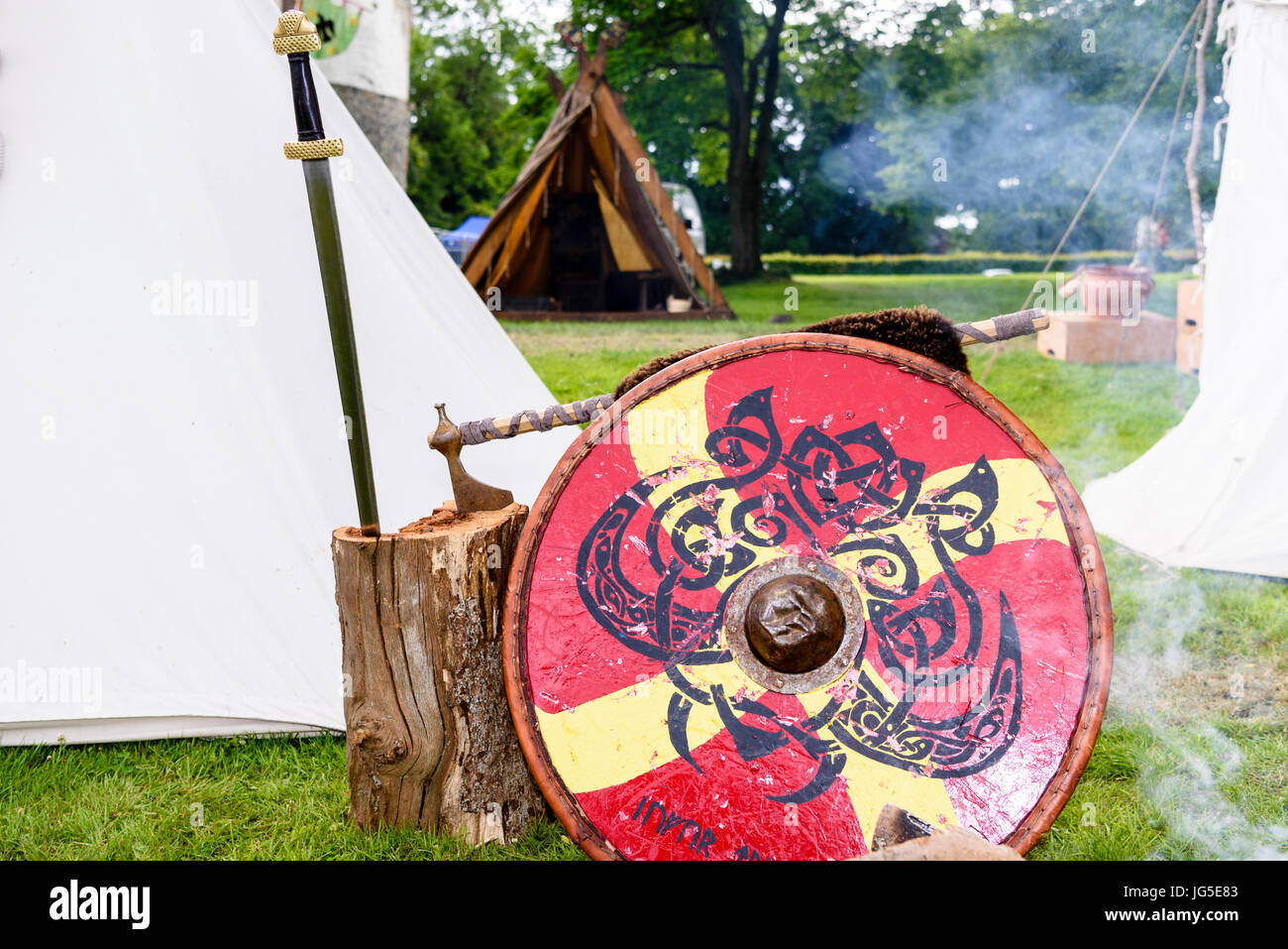 Schwert, Axt und Schild, eine mittelalterliche Soldat neben einem Feuer auf einem Campingplatz Armee angehören. Stockfoto