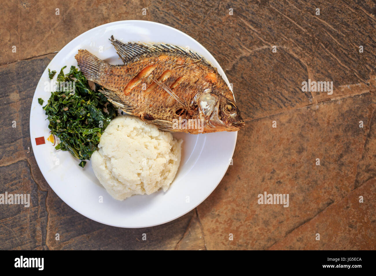 Traditionelle ostafrikanische Küche - Grüns in Kenia, Ugali und Fisch Stockfoto