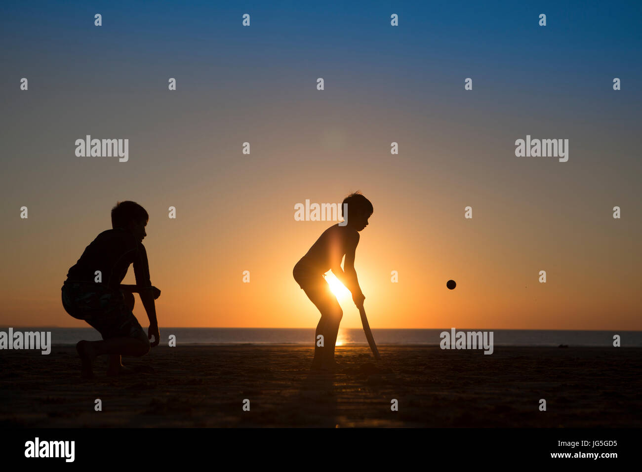 Kinder Fussball am Strand, als die Sonne, Devon, UK untergeht Stockfoto