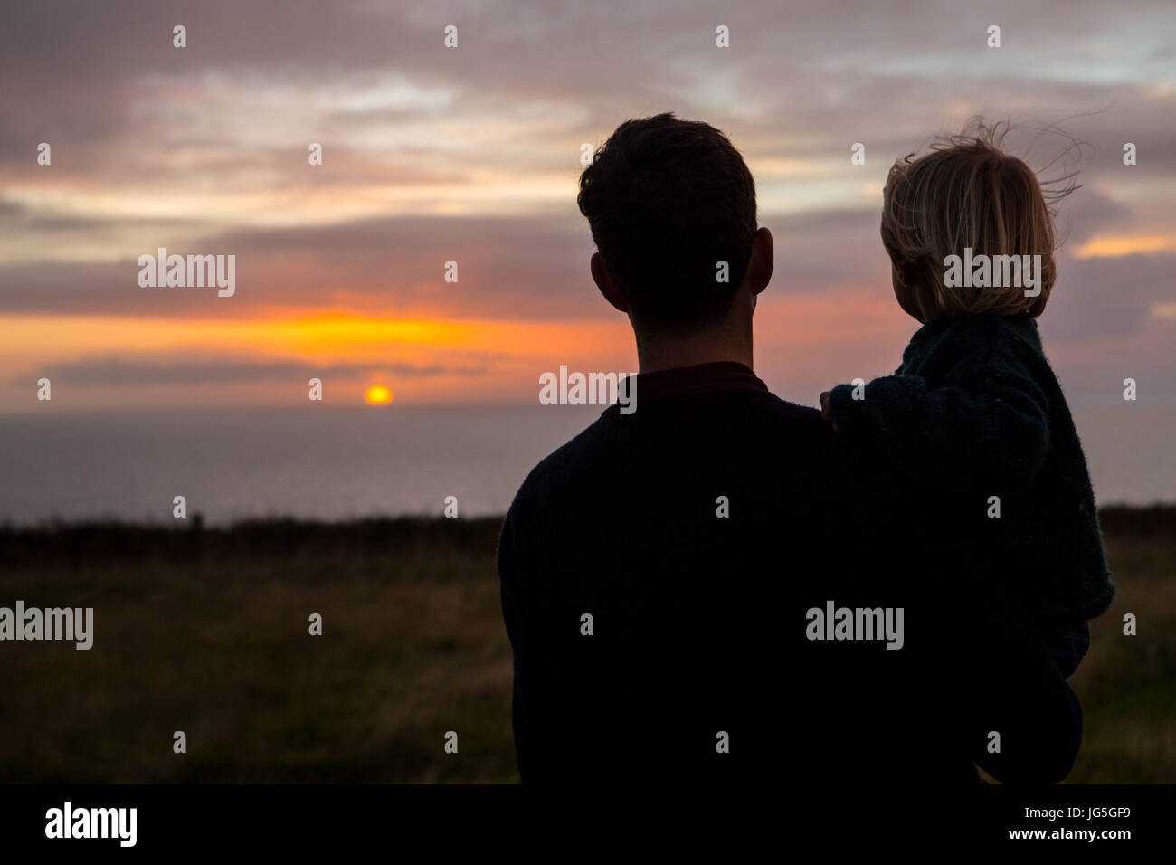 Eine Silhouette von Mann und Kind, den Sonnenuntergang, UK. Stockfoto