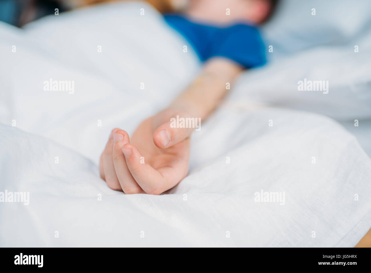 Teilansicht des kleinen Jungen im Krankenhausbett liegend Stockfoto