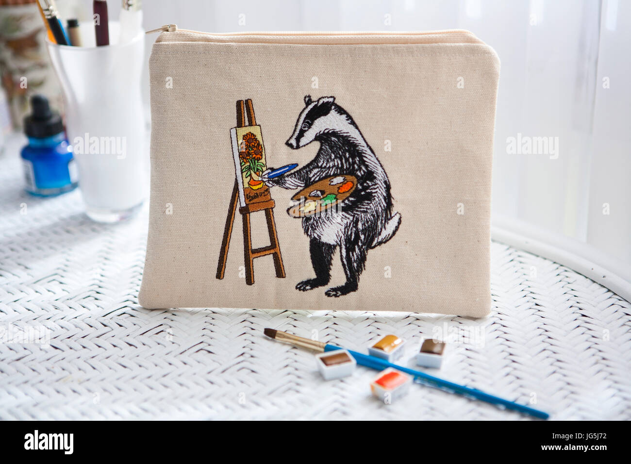 Materialien auf Schreibtisch mit Reißverschlussbeutel Darstellung einer gestickten Badger Gemälde Van Goghs Sonnenblumen Stockfoto