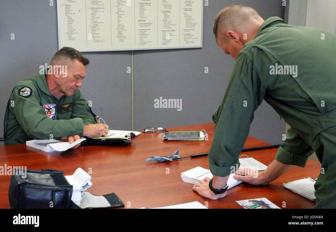 Generalleutnant Jon Davis hört die Aktion kurz vor dem Flug unter der Leitung von Oberst John Rahe im Marine Corps Air Station Cherry Point, North Carolina, 30. Juni 2017. Davis trat das Marine Corps im Mai 1980 und wurde von zertifizierten Pilot auf der Harrier AV-8A im September 1982. Davis ist der stellvertretende Kommandant für die Luftfahrt. Rahe ist der Assistent-Flügel-Kommandant der 2. Marine Aircraft Wing. (Foto: U.S. Marine Corps Lance Cpl. Justin Roux / veröffentlicht) Stockfoto