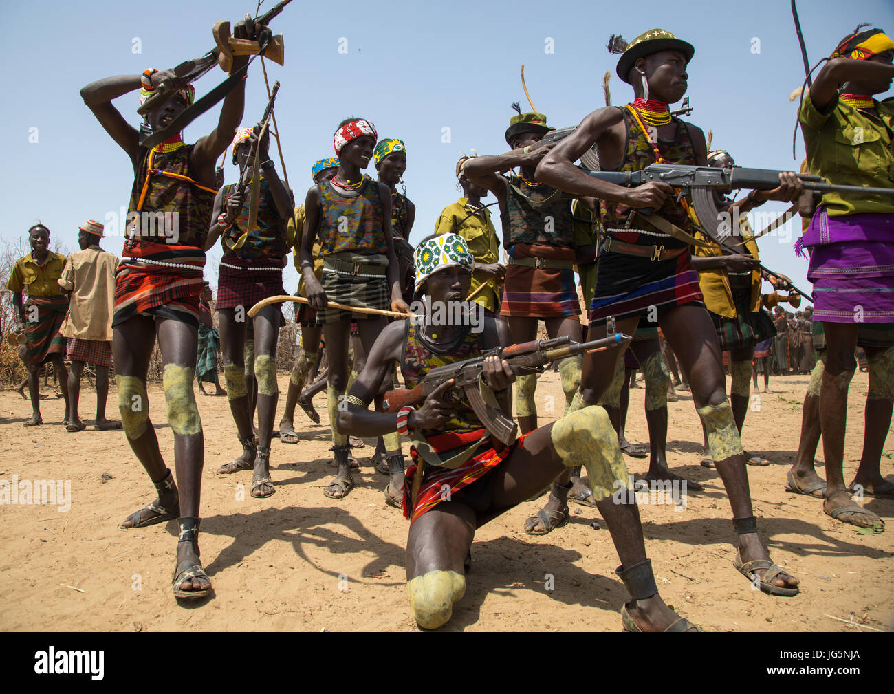 Männer schießen mit Kalaschnikows während der Zeremonie stolz Ochsen in den Dassanech Stamm, Turkana County, Omorate, Äthiopien Stockfoto
