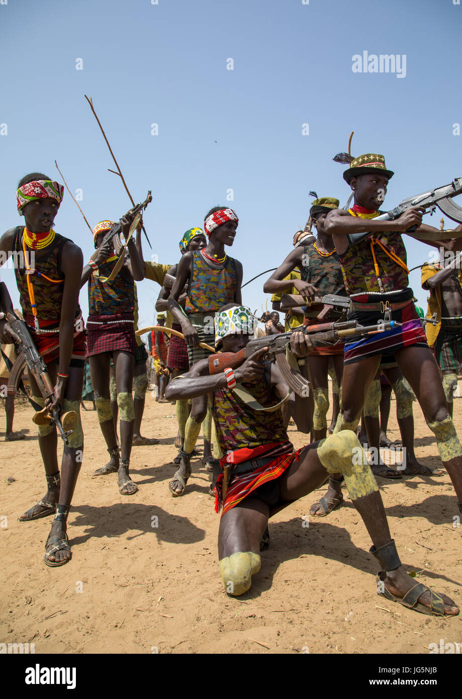 Männer schießen mit Kalaschnikows während der Zeremonie stolz Ochsen in den Dassanech Stamm, Turkana County, Omorate, Äthiopien Stockfoto