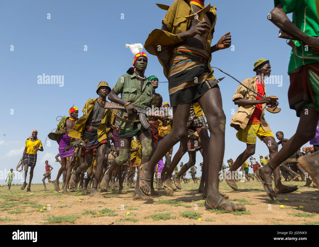 Männer, die im Einklang mit Waffen ausgeführt, während der Zeremonie stolz Ochsen in den Dassanech Stamm, Turkana County, Omorate, Äthiopien Stockfoto