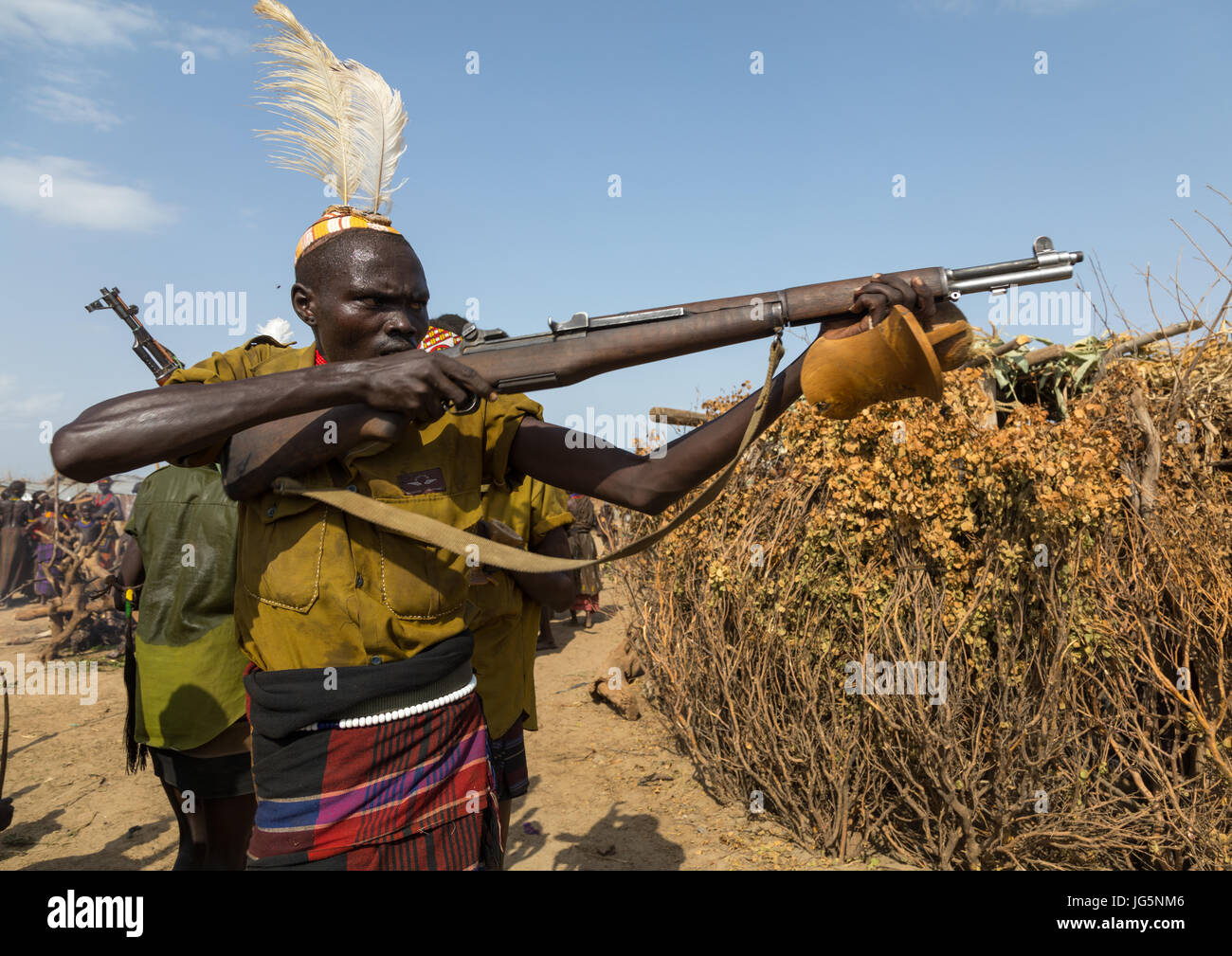 Mann mit einer Kalaschnikow schießen, während der Zeremonie stolz Ochsen in den Dassanech Stamm, Turkana County, Omorate, Äthiopien Stockfoto