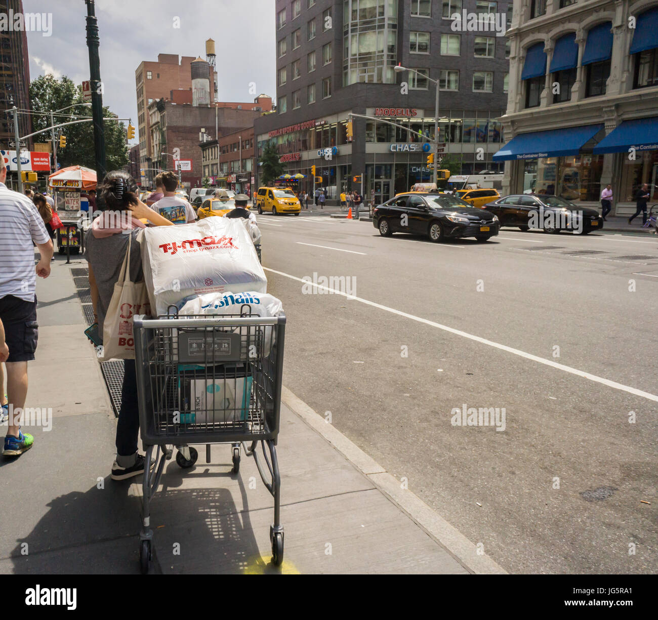 Eine Shopper geladen mit ihren Einkäufen aus dem Off Einzelhandel T. J. Maxx und Marshals wartet für den Transport außerhalb des Shops auf Dienstag, 27. Juni 2017.  (© Richard B. Levine) Stockfoto