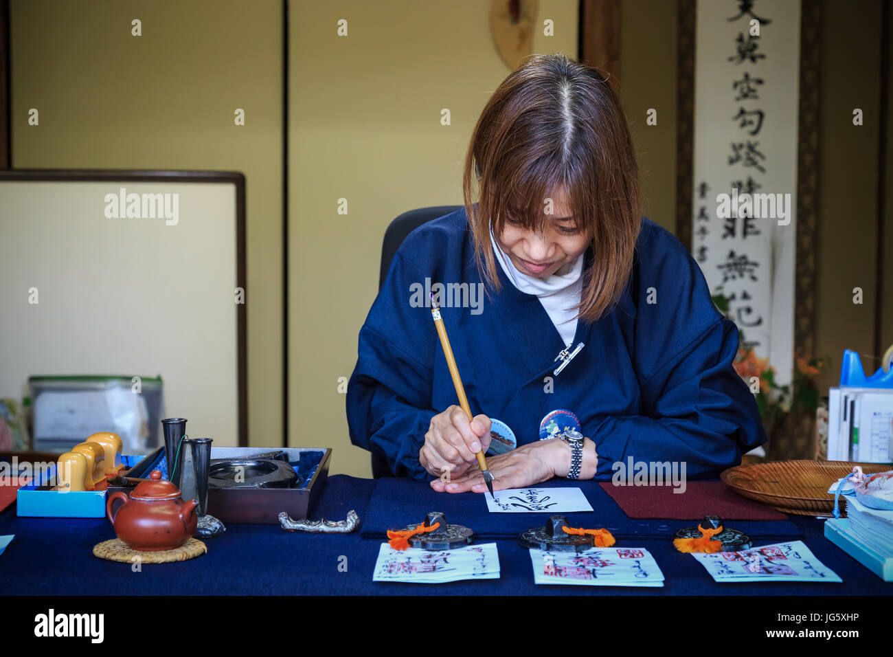 KYOTO, JAPAN - 21.Oktober: Religiöse Freiwillige in Kyoto, Japan am 21. Oktober 2014. Nicht identifizierte religiöse freiwillig schreibt auf einem Papier für Kalligraphie Stockfoto