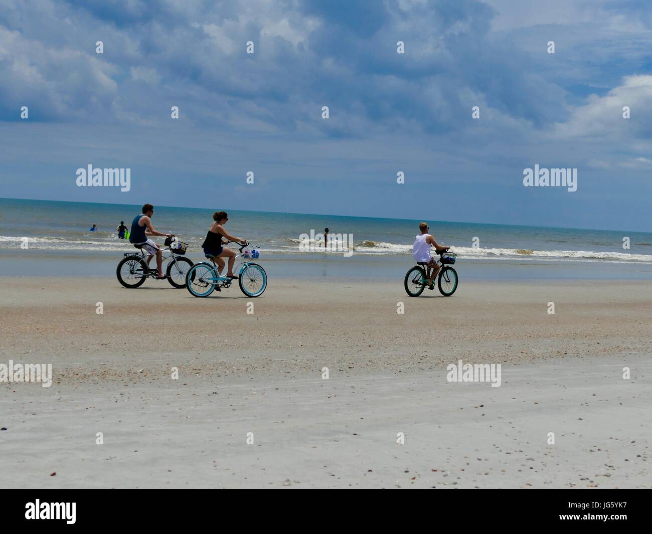 Menschen Reiten Fahrräder auf Florida Beach und das Spielen in den Atlantischen Ozean. St. Augustine Beach, Florida, USA. Stockfoto