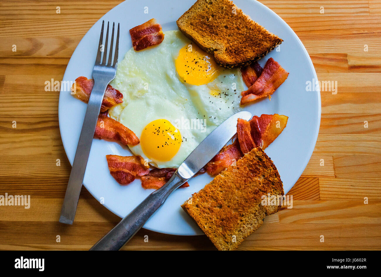 Zwei Eiern Sonnenseite mit knackigen Speck und Vollkorn toast Stockfoto