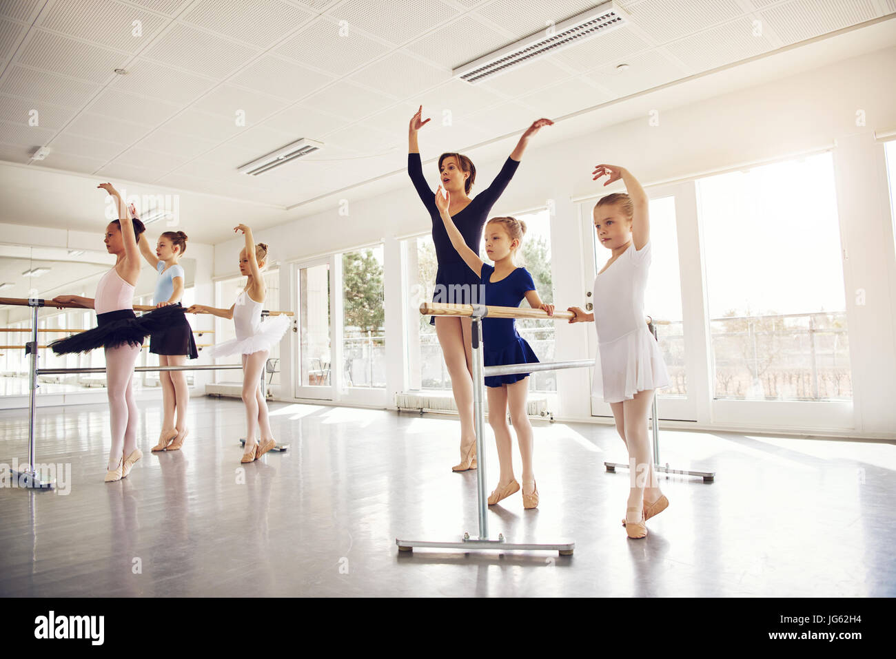 Junge Mädchen und Lehrerin mit Händen stehend beim Ballett in der Klasse durchführen. Stockfoto