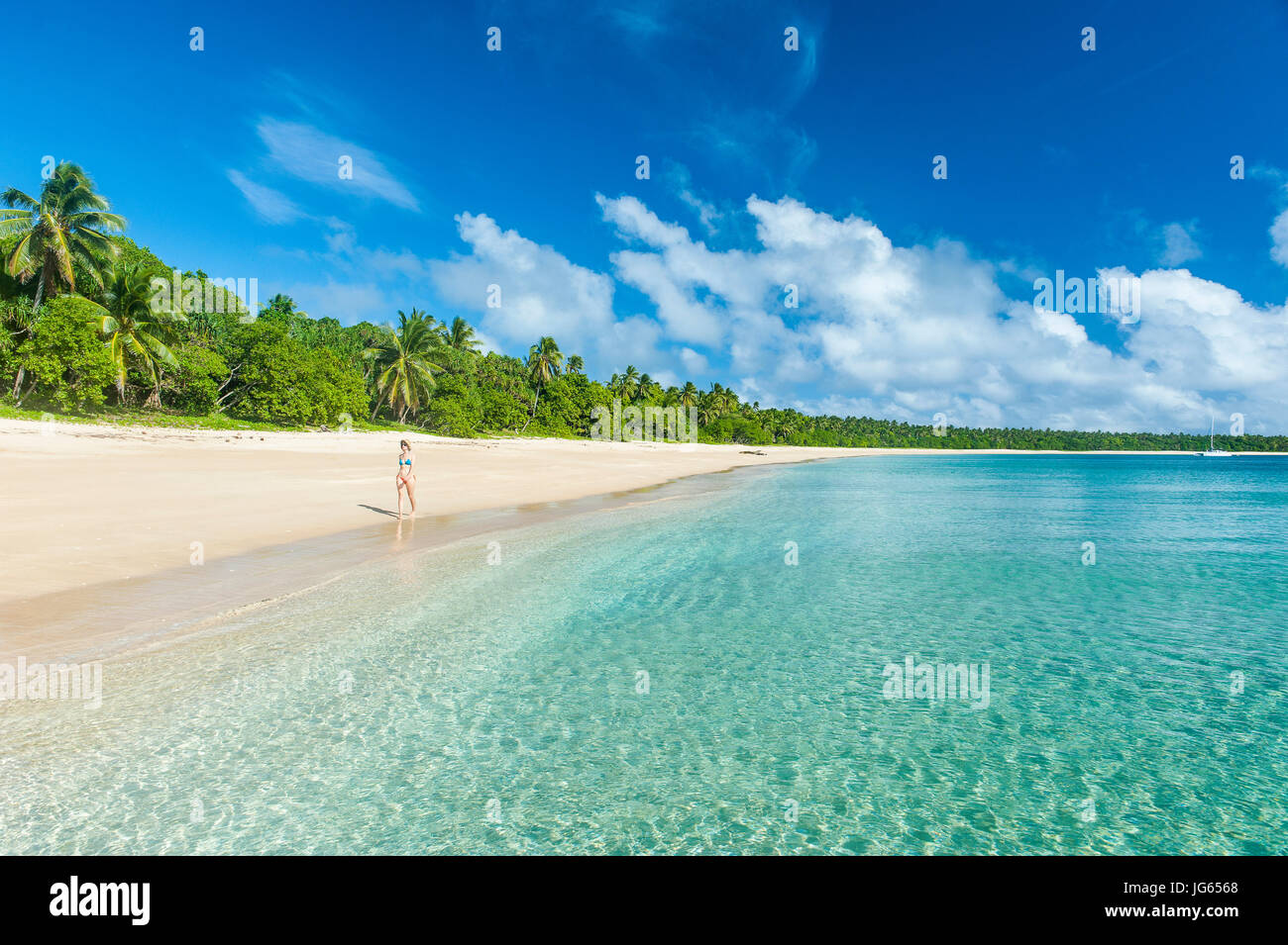 Frau zu Fuß auf einem Palm gesäumten weißen Sandstrand in Ha´apai, Haapai, Inseln, Tonga, South Pacific, Herr Stockfoto