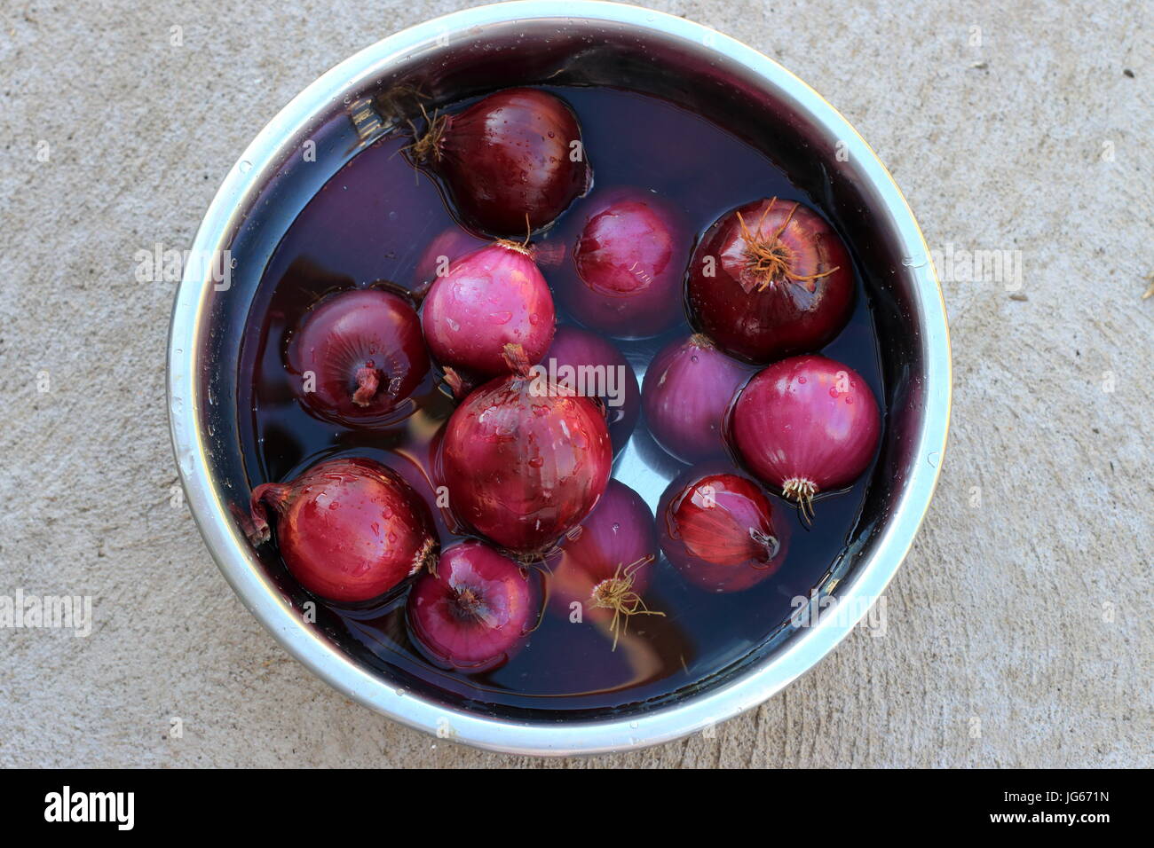 Rote Zwiebeln in klarem Wasser einweichen Stockfoto