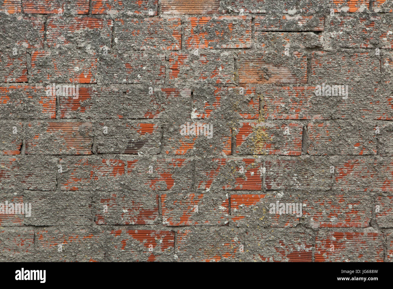 Mauer ist teilweise mit Zement bedeckt. Hintergrundtextur. Stockfoto