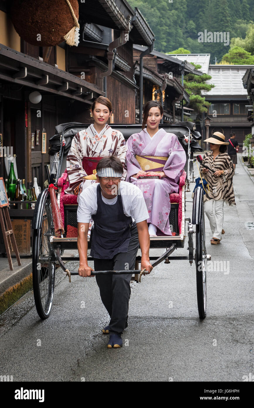 Geisha in traditioneller Kleidung mit traditionellen japanischen öffentlichen Verkehrsmitteln, menschliche macht Rikschas. Takayama-Japan. Stockfoto