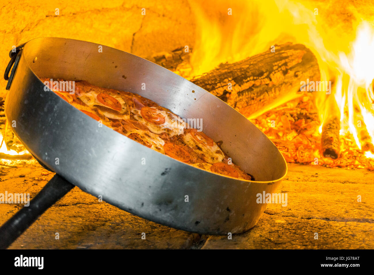 Leckere Pizza im Ofen mit Brennholz, Italien Stockfoto