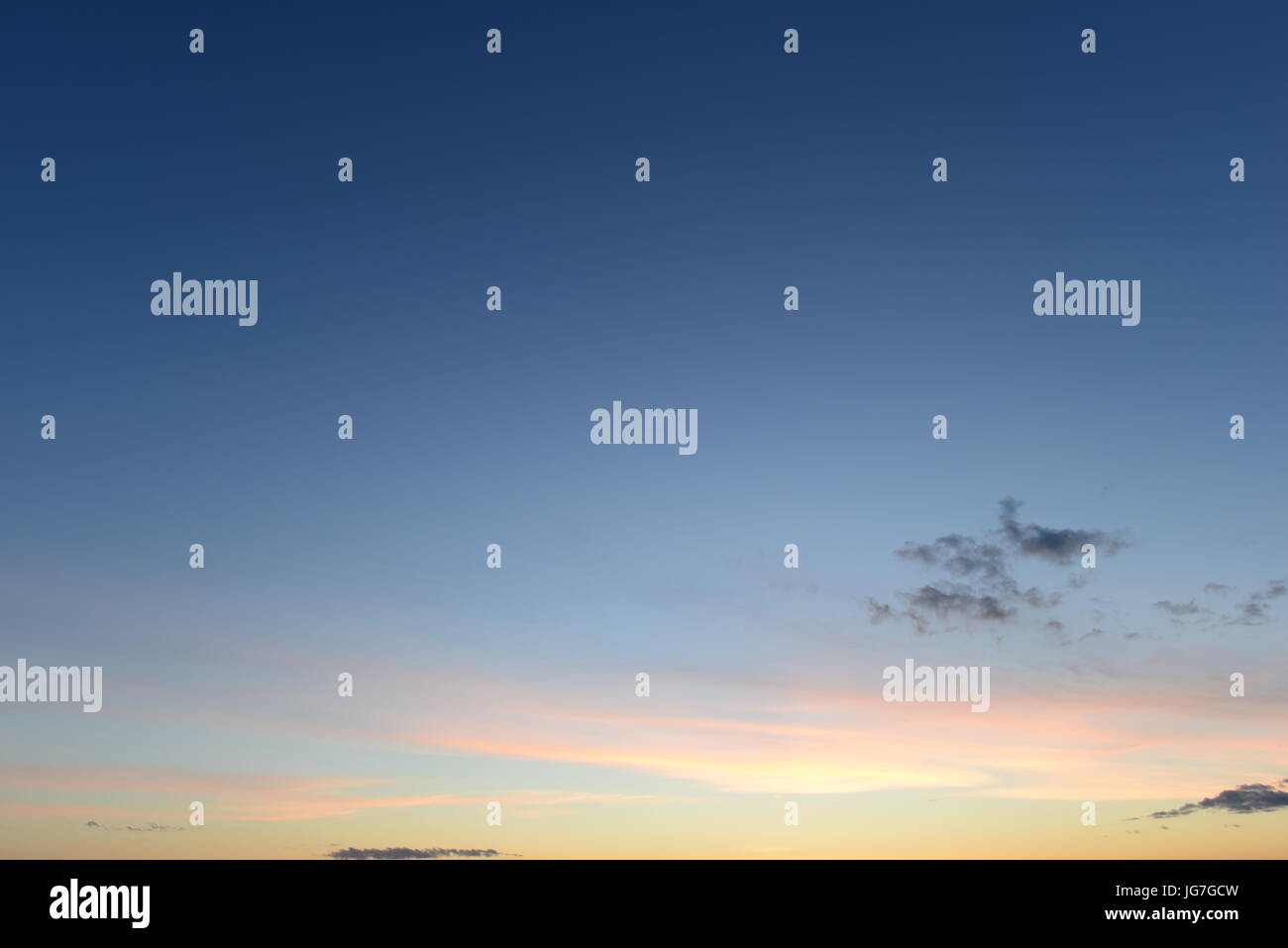 Klarer blauer Himmel mit einem hellen rosa Schein aus den Sonnenuntergang Stockfoto