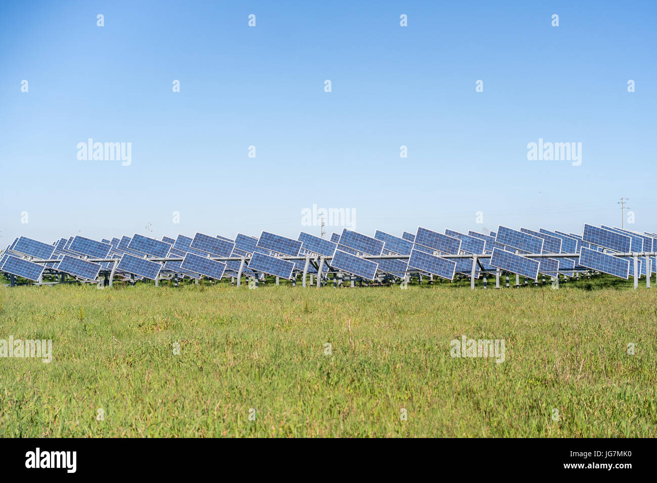 Kleine Solar-Panels auf dem grünen Rasen gegen blauen Himmel Stockfoto