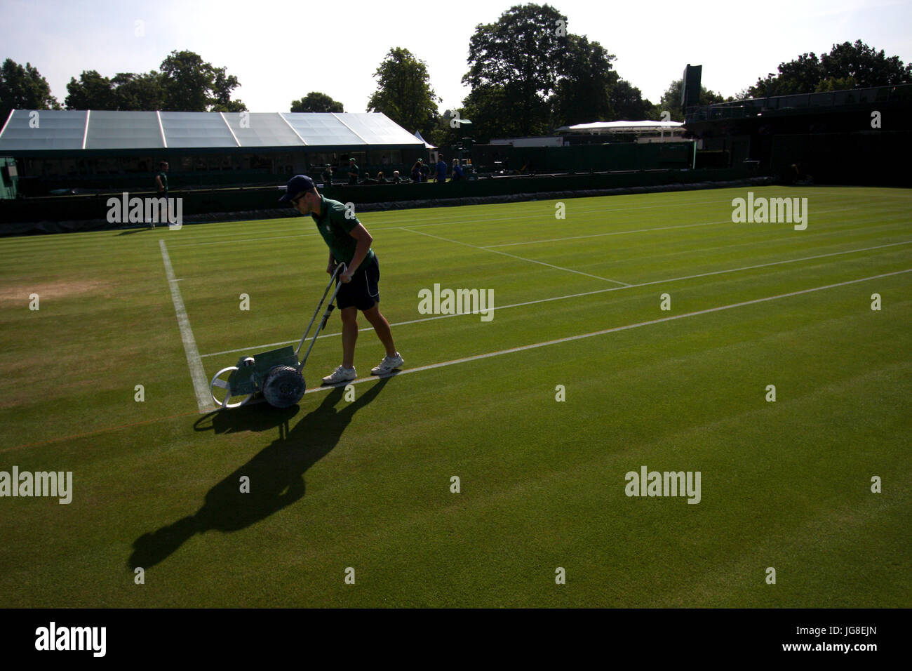 London, UK. 4. Juli 2017. Ein Hotelpage Kreide die Linie von einer der äußeren Gerichte bei den All England Lawn Tennis Club als Vorbereitung für Tag 2 von Wimbledon. Bildnachweis: Adam Stoltman/Alamy Live-Nachrichten Stockfoto