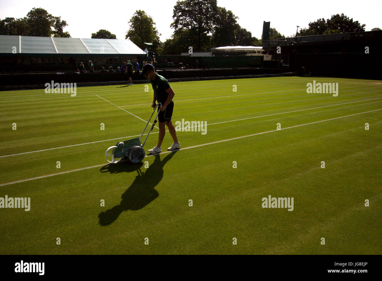 London, UK. 4. Juli 2017. Ein Hotelpage Kreide die Linie von einer der äußeren Gerichte bei den All England Lawn Tennis Club als Vorbereitung für Tag 2 von Wimbledon. Bildnachweis: Adam Stoltman/Alamy Live-Nachrichten Stockfoto